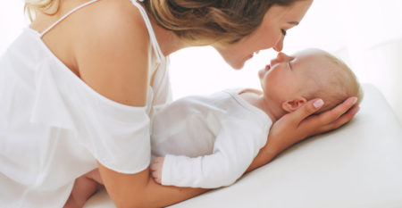 Young mother holding her newborn child. Mom nursing baby. Woman